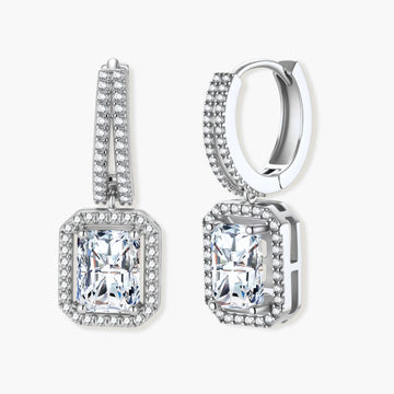 Sterling silver huggie hoops with emerald-cut moissanite drops featuring pavé-set crystals on white background.