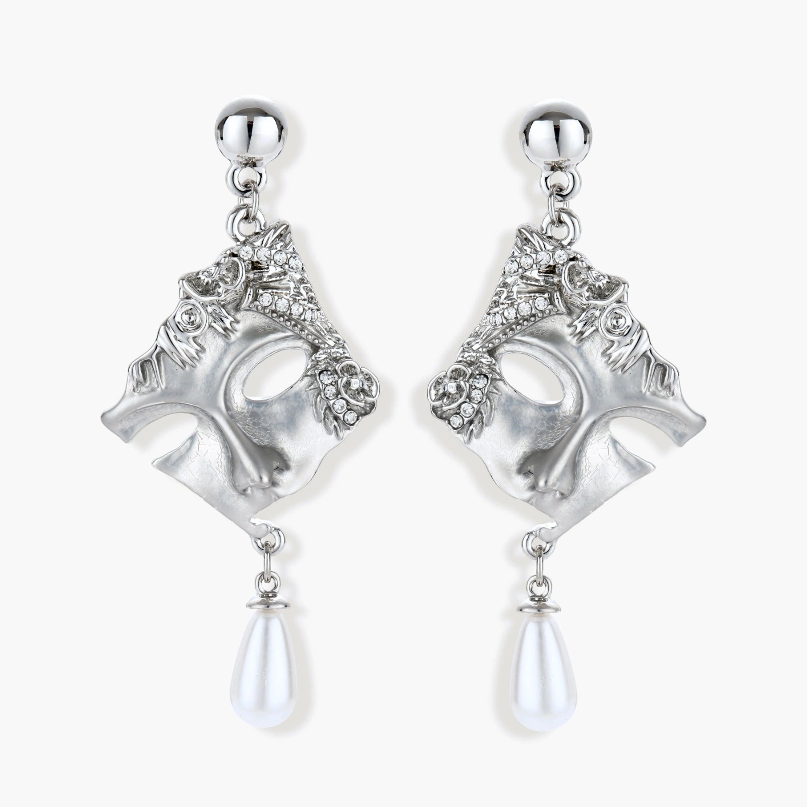 Ornate silver-toned theatrical mask earrings with crystal details and pearl drops on white background.