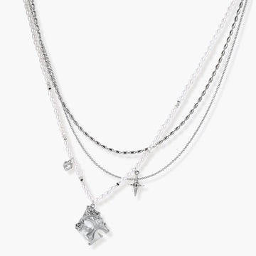 Multi-strand layered necklace set with silver chains, white pearls, star charm, heart pendant, and ornate decorative piece