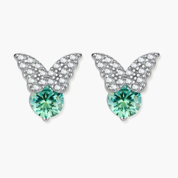 Sterling silver butterfly stud earrings with crystal wings and mint green center stones on cream background.