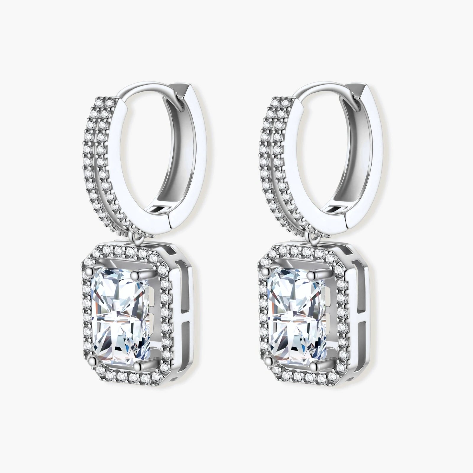 Sterling silver huggie hoops with emerald-cut moissanite drops featuring pavé-set crystals on white background.