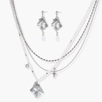 Ornate silver-toned masquerade mask jewelry set featuring rhinestone details and pearl drop earrings on white background.