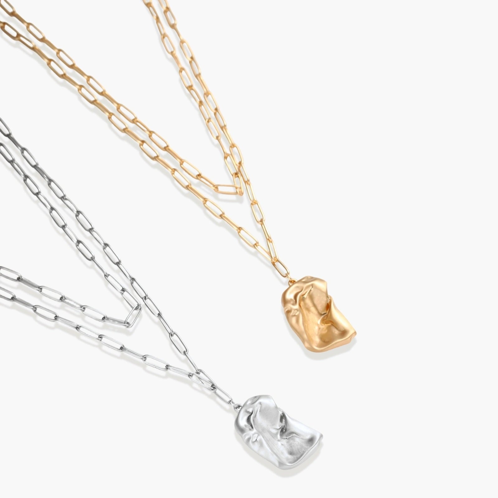Silver layered necklace with organic flowing pendant in eco-zinc alloy on neutral background, showing adjustable chain design.