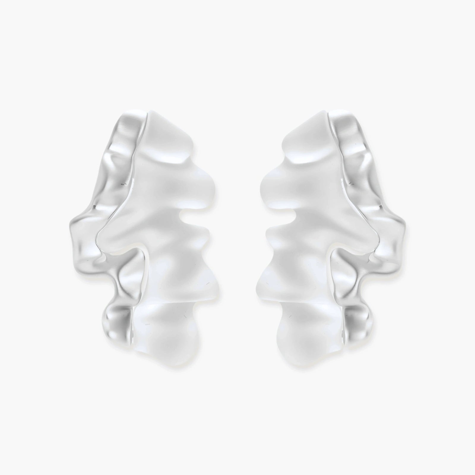 Pair of silver-toned sculptural earrings with flowing abstract forms and stud backs against white background.