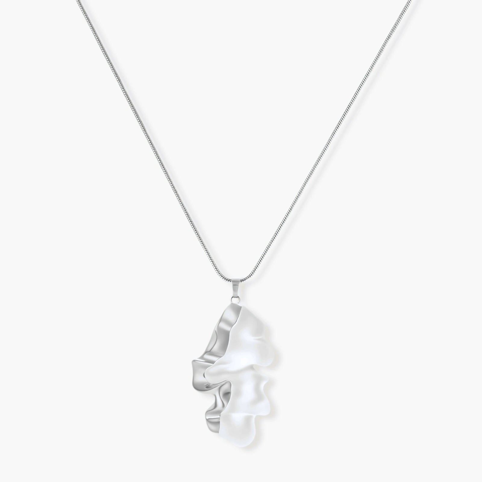 Modern sculptural pendant necklace with twisted metallic design on delicate silver chain against neutral background.