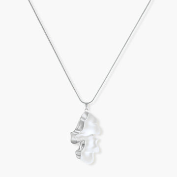 Modern sculptural pendant necklace with twisted metallic design on delicate silver chain against neutral background.