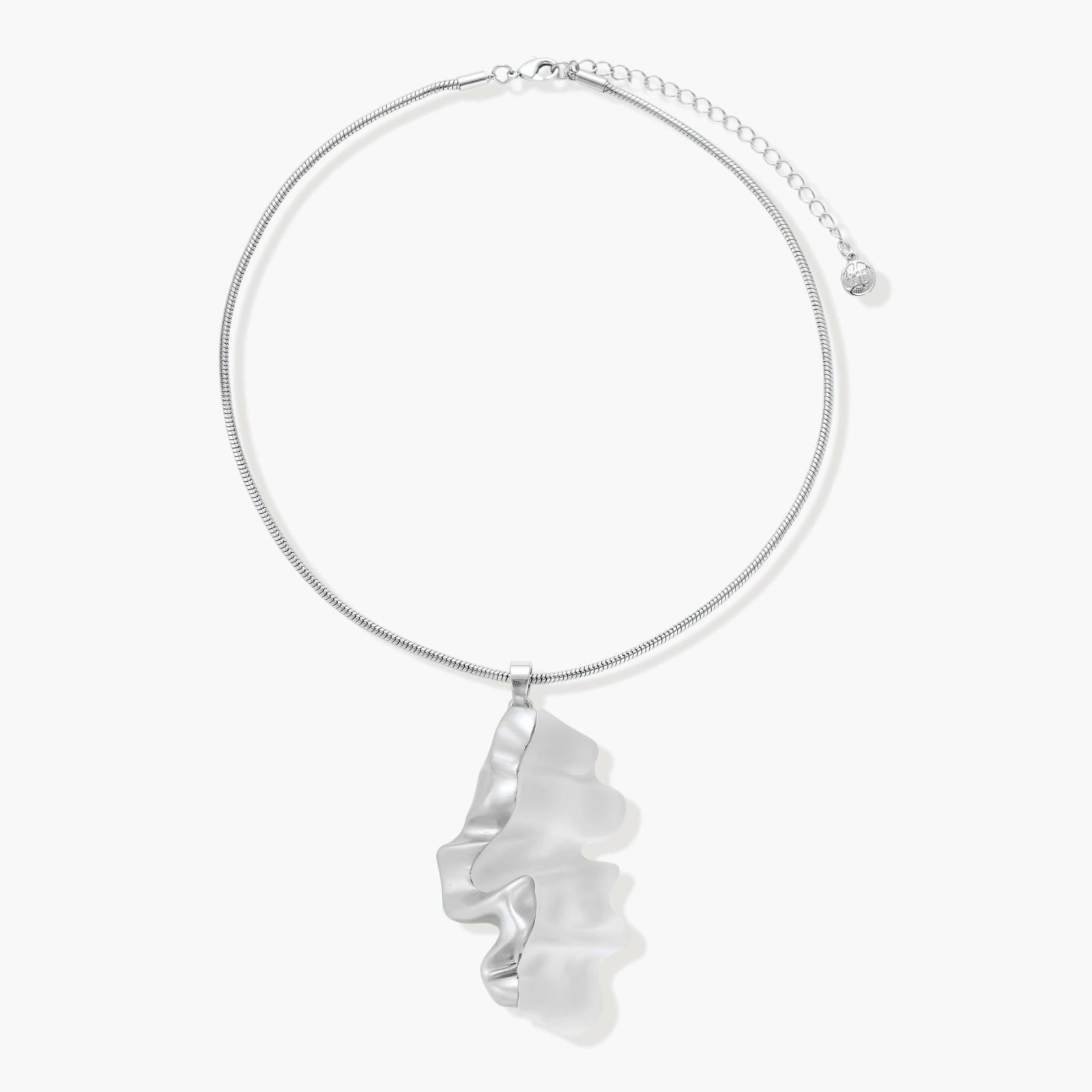 Modern sculptural pendant necklace with twisted metallic design on delicate silver chain against neutral background.